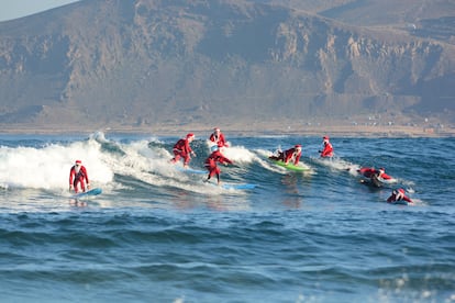 Surfistas de la escuela Mojo Surf cogen olas disfrazados de Papá Noel en la playa de Las Canteras (estas fiestas lo harán  entre el 18 y el 22 de diciembre).