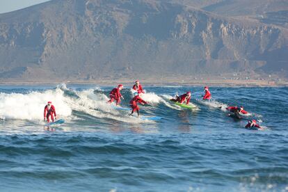 Surfistas de la escuela Mojo Surf cogen olas disfrazados de Papá Noel en la playa de Las Canteras (estas fiestas lo harán  entre el 18 y el 22 de diciembre).