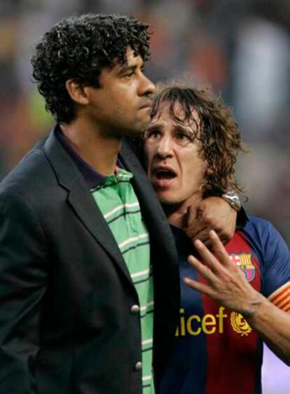 Rijkaard consuela a Puyol al término del partido.