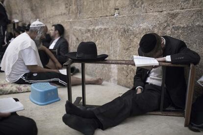 Judíos ortodoxos asisten a una oración nocturna para marcar el Tisha BeAv en el Muro de las Lamentaciones, en la antigua ciudad de Jerusalén (Israel).