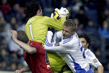 Ricardo ataja el balón rodeado por dos jugadores.