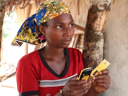 La joven Aisuto, con el teléfono móvil que le sirve para comprar comida, en el campo de refugiados de Lolo (Camerún).