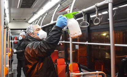 Personal de la empresa de autobuses iraní desinfecta un vehículo en Teherán.