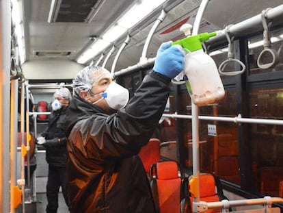 Personal de la empresa de autobuses iraní desinfecta un vehículo en Teherán.