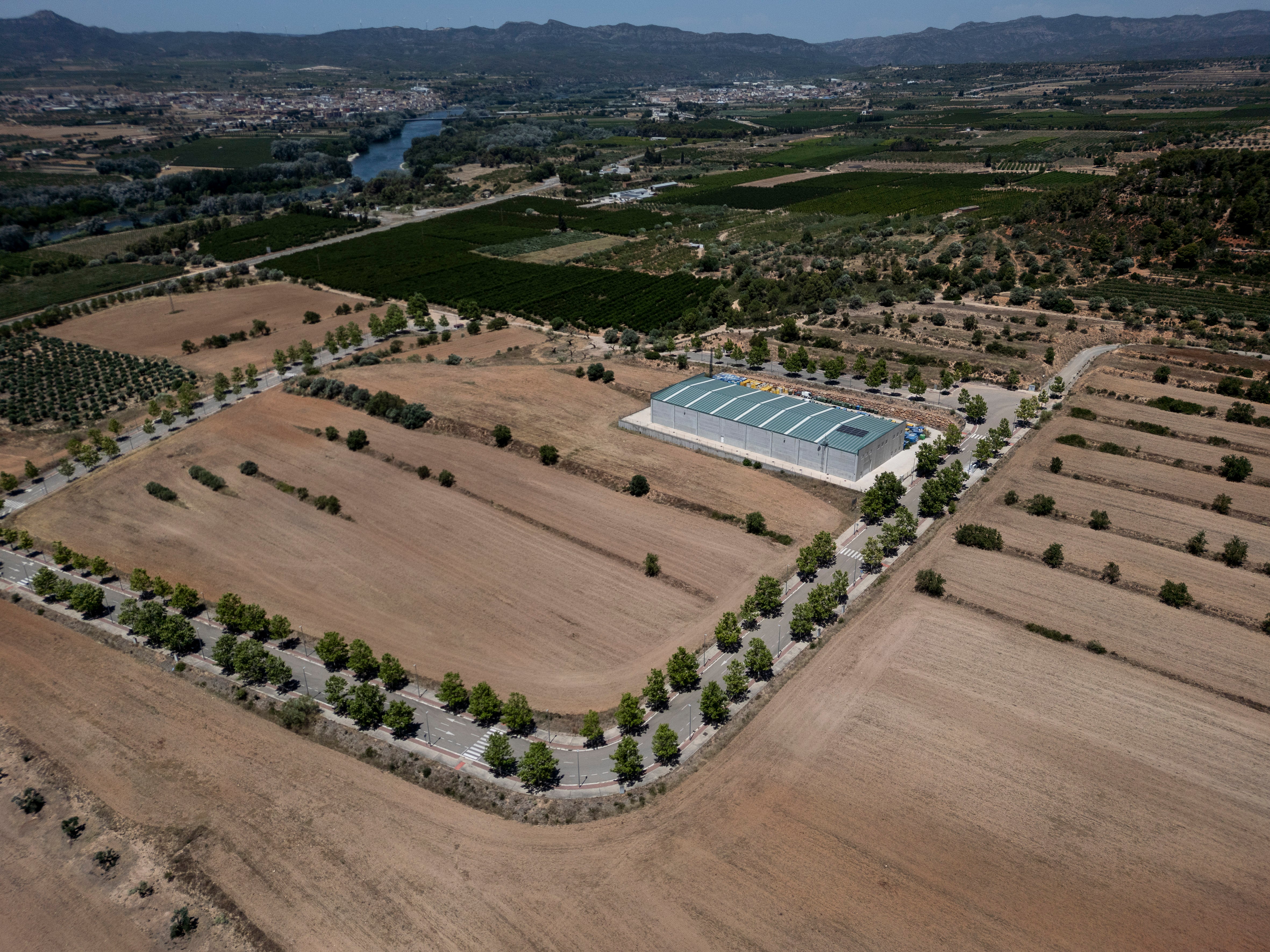 Vista aérea del polígono industrial El Molló de Mora la Nova, espacio donde se proyecta una gigafactoría de inteligencia artificial (IA) promovida por la Unión Europea. De fondo, el río Ebro.