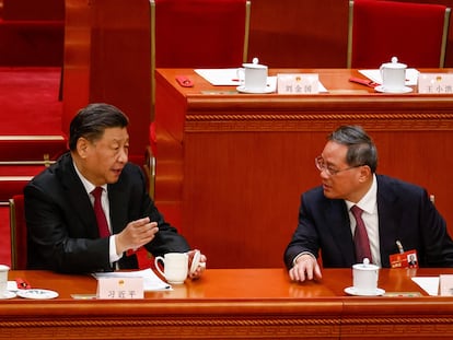 El presidente chino, Xi Jinping, habla con el primer ministro entrante, Li Qiang, durante la reunión de la Asamblea Popular Nacional, este viernes en Pekín.