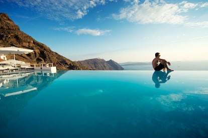 Un hombre en una piscina de Santorini, Grecia.