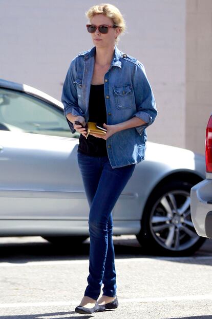 Charlize Theron combina bailarinas de ante con un look vaquero.