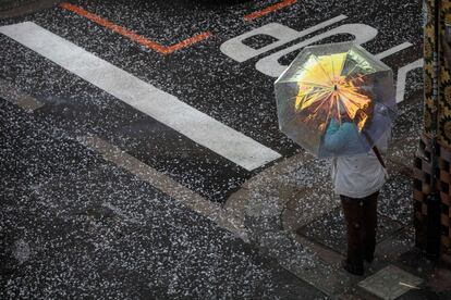 Una persona se protege del granizo con un paraguas este viernes en la ciudad de Valéncia.