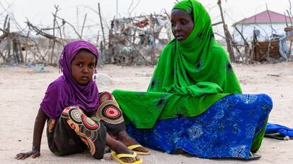 Hawo Mohamed, antigua pastora afectada por el cambio climático, y su hija Yasmin en su parcela de Berbera, en Somalilandia.