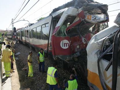 Dos operarios junto a los trenes siniestrados en Valencia.