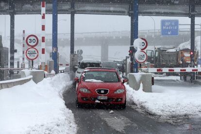 Algunos automóviles salen de la autopista AP6 después de haber quedado atrapados durante la noche debido a la primera fuerte nevada de este invierno en Villacastin, provincia de Segovia.