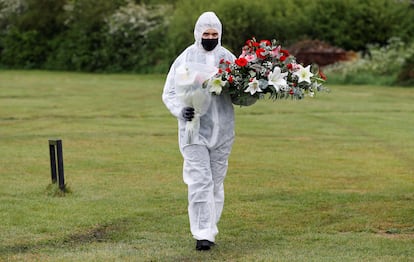 Un empleado de servicios funerarios durante un entierro en un cementerio londinense.