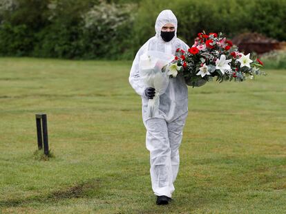 Un empleado de servicios funerarios durante un entierro en un cementerio londinense.