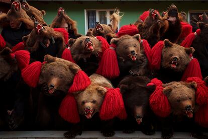 Members of the Sipoteni bear pack strike the final pose of their performance in Preluci, northern Romania, Tuesday, Dec. 26, 2023, while touring village homes.