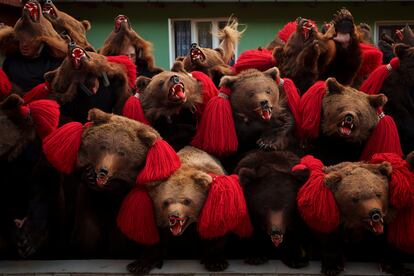 Members of the Sipoteni bear pack strike the final pose of their performance in Preluci, northern Romania, Tuesday, Dec. 26, 2023, while touring village homes. 