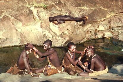 Etipía, 1988. "Mientras parte de los adolescentes de la tribu surma, del suroeste del país, se pintan la cara en la orilla del río, un niño duerme la siesta enfrente. Él dice que estaba dormido aunque muy cómodo no parece".