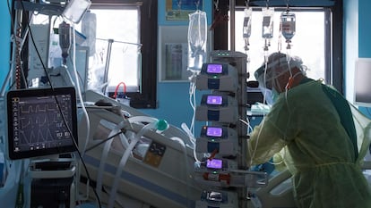 A Covid-19 patient is attended to by a medical worker in a Spanish hospital.