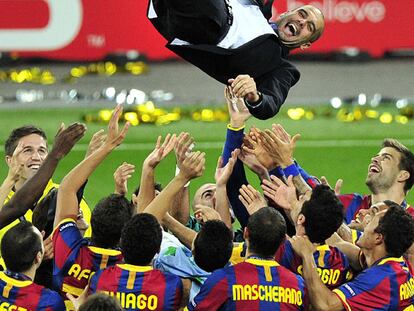 Guardiola, manteado por sus jugadores a la conclusión del partido.