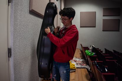 Julio Linares, vocal de cuerdas, guarda su chelo dentro de una sala tomada por los estudiantes del Conservatorio.