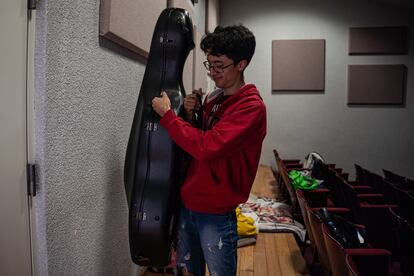 Julio Linares, vocal de cuerdas, guarda su chelo dentro de una sala tomada por los estudiantes del Conservatorio. 