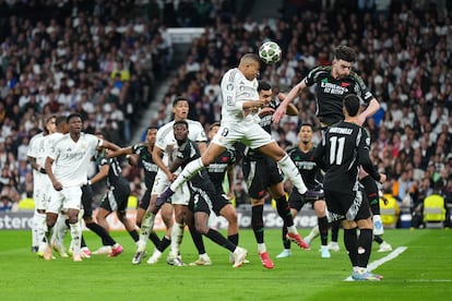 Kylian Mbappe, del Real Madrid, remata un balón de cabeza ante la presencia de Rice, del Arsenal.