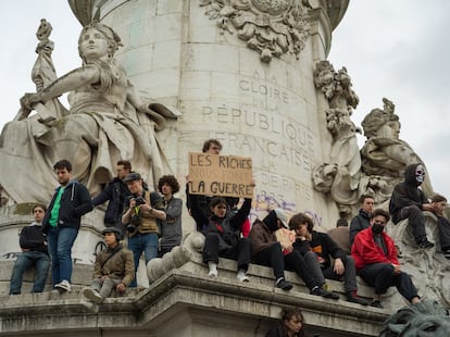 Manifestantes portan pancartas en contra de Macron en el monumento de la plaza de la República de París, el jueves.