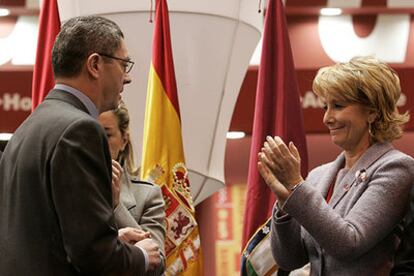 Esperanza Aguirre aplaude ante Alberto Ruiz-Gallardón en un acto celebrado ayer en la Feria de Turismo de Madrid.