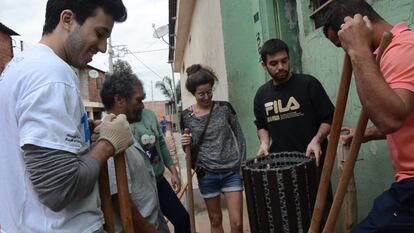 Moradores y voluntarios distribuyen sus tareas en un 'mutirão', para colocar papeleras por todas las calles de la comunidad.

