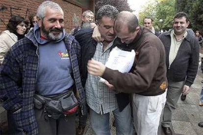Dos trabajadores de Caballito se abrazan emocionados, ayer, tras la firma del acuerdo con la empresa que ha puesto fin a los dos años de huelga.