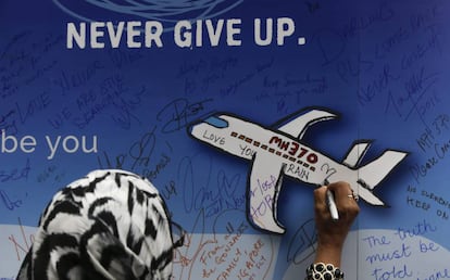 Mulher deixa uma mensagem em um memorial das vítimas do voo MH 370 em Kuala Lumpur, na Malásia, em março de 2016.