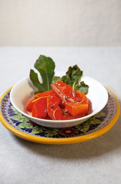 <p><i>Papaya con miel y limón. Región: Yucatán, Tabasco </i></p><p><b> Ingredientes</b></p><p> Para 6-8 personas: 3 cucharadas de cal viva, 1 kilogramo de papayas peladas, despepitadas y troceadas, 15-20 hojas de higuera frescas, 475 mililitros de miel, la piel de 2 limones sin albedo (la parte blanca) cortada en tiras finas, una ramita de canela. Para servir (opcional): queso gruyer rallado, azúcar moreno, helado de vainilla o nata. </p><p><b> Preparación</b></p><p> <i> Preparación: 30 minutos, más una hora para reposar y 2 horas para enfriar. Cocción: una hora y 20 minutos. </i></p><p>1. Disolver la cal viva en un bol con 475 mililitros de agua y verter sobre la papaya. Añadir la cantidad de solución necesaria para cubrir la fruta. Dejarla reposar una hora. 2. Forrar el fondo de una cazuela ancha con la mitad de las hojas de higuera. Escurrir las papayas y lavarlas bien con agua fría. Introducirlas en la cazuela preparada y añadir la miel, las tiras de limón y la ramita de canela. Cubrirlas con las hojas de higuera restantes y con papel vegetal, en ese orden. 3. Hacer una pequeña incisión en el centro del papel para que el vapor pueda salir durante la cocción. 4. Cocer la papaya a fuego lento durante una hora, o hasta que esté tierna. Retirar la cazuela del fuego, dejar que la papaya alcance la temperatura ambiente e introducirla en el frigorífico. 5. Cuando esté fría, colocarla sobre una fuente de servir y verter el líquido de cocción por encima. Adornarla con queso, azúcar moreno, helado de vainilla o nata (opcional).</p>