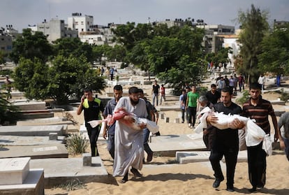 Parientes de dos niños palestinos portan sus cuerpos en el cementerio del campo de refugiados Jebaliya en el norte de la Franja de Gaza, durante su funeral.