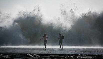 Una pareja intenta hacer una foto en la playa de Barcelona.