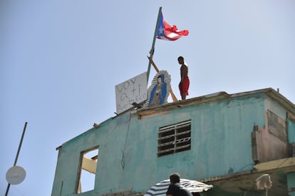 Un hombre permanece en lo alto de su casa, dañada por el huracán María en Yabucoa (Puerto Rico).