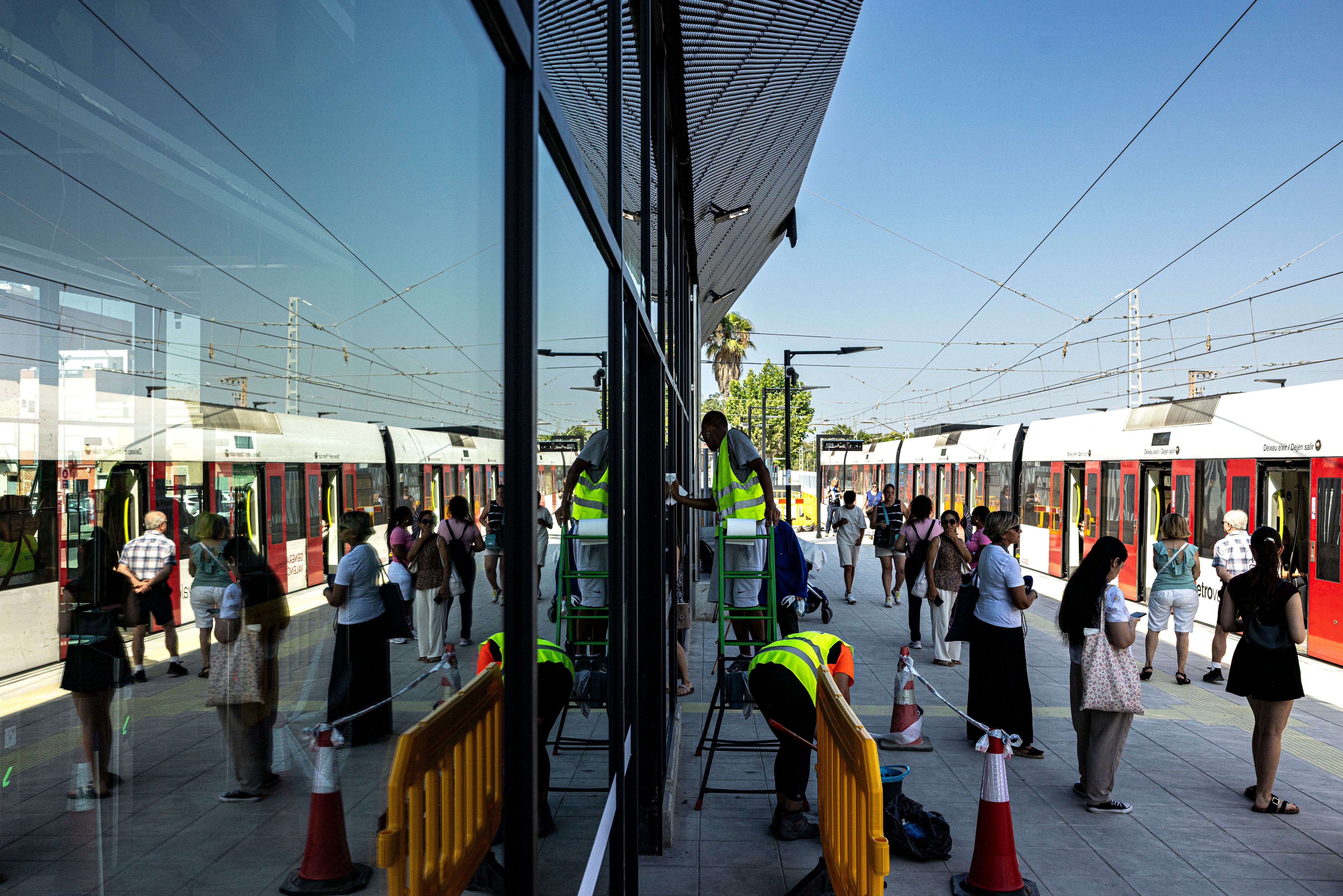 Estación del metro de Paiporta con viajeros y operarios acabando las obras, este viernes por la mañana.