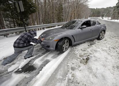 Un hombre empuja su coches en una carretera en Chapel Hill, N.C, 13 de febrero de 2013. Filadelfia y Nueva York, donde se ha declarado el estado de emergencia, esperan entre 30 y 40 centímetros de nieve a lo largo del día, ya que se pronostica que continuará nevando en toda la costa este del país esta jornada casi de manera ininterrumpida.