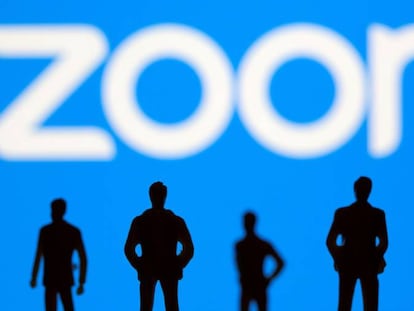 Pequeñas figuras de juguete junto al logo de Zoom. 