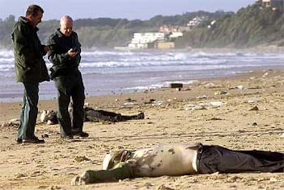 Dos guardias civiles, en una playa de Rota junto al cuerpo de uno de los inmigrantes fallecidos.