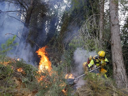 Un bombero trabaja para el extinción del incendio forestal en la localidad valenciana de Ador, este sábado.