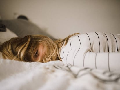 Una mujer está despierta en la cama. 