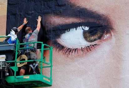 Unos operarios colocan un poster en los exteriores de del Comic-Con, el 17 de julio de 2018.