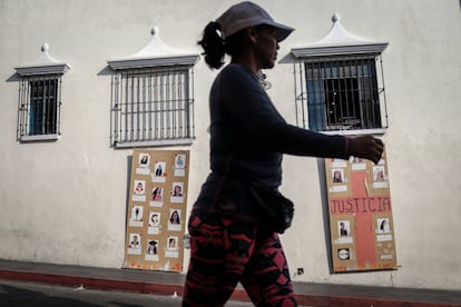 Una mujer camina frente a fotografías de mujeres desaparecidas y víctimas de feminicidio, en México.