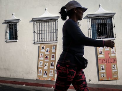 Una mujer camina frente a fotografías de mujeres desaparecidas y víctimas de feminicidio, en México.