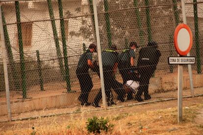 Agentes de la guardia civil expulsan por la valla de Melilla a un inmigrante subsahariano que había paricipado en un salto a la valla de Melilla en 2014.