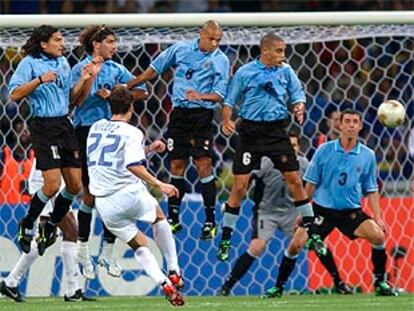 Micoud lanza una falta ante los jugadores de Uruguay.