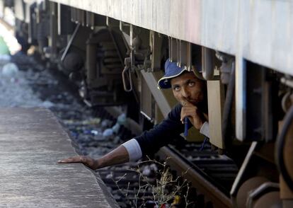 Un migrante, escondido debajo de un tren, intenta colarse en un tren hacia Serbia, en la estación de ferrocarril en Gevgelija (Macedonia).