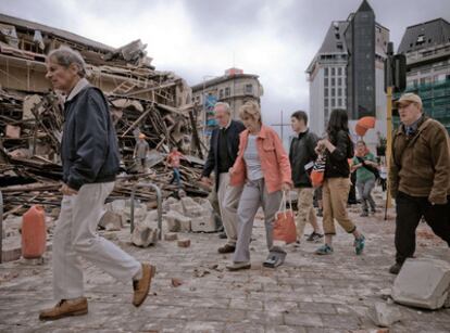 Un grupo de personas camina entre los escombros en la ciudad de Christchurch, tras el terremoto de 6.3 grados.