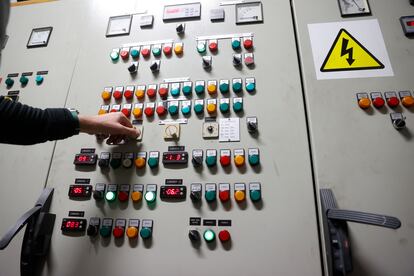 Un hombre controla un panel de electricidad.