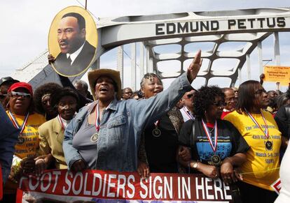 Dorothy Tillman Wright, en el centro, una de las manifestantes que participó en la marcha de 1965, grita eslóganes en la conmemoración de hoy. Detrás de ella, un retrato de Martin Luther King, que abanderó la protesta hace 50 años.